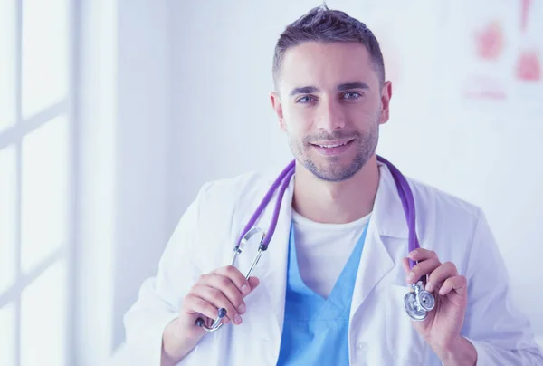 Młody i pewny siebie mężczyzna lekarz portret stojący w medycznym off — Zdjęcie stockowe