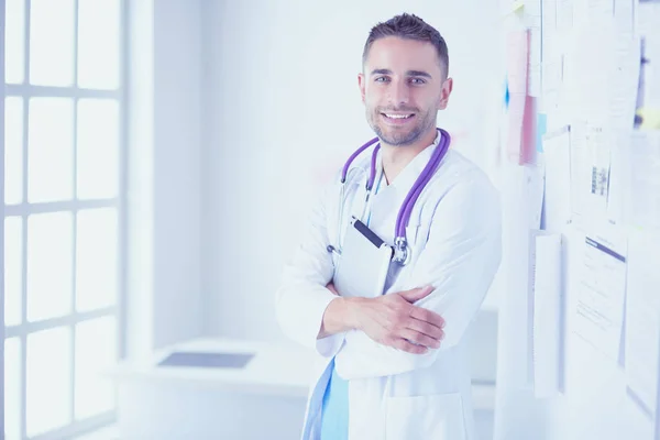 Młody i pewny siebie mężczyzna lekarz portret stojący w medycznym off — Zdjęcie stockowe