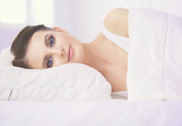 Νεαρή όμορφη γυναίκα ξαπλωμένη στο κρεβάτι. — Φωτογραφία Αρχείου