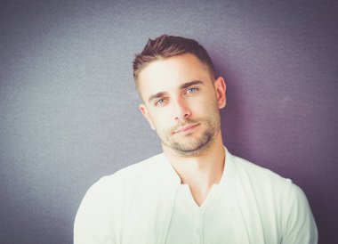 Genç iş adamı beyaz arka planda tek başına duruyor.