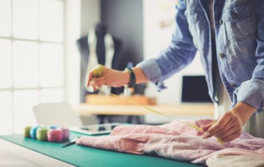 Moda tasarımcısı kadın stüdyoda tasarımları üzerinde çalışıyor..