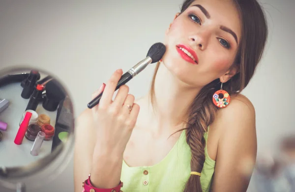 Ung vacker kvinna gör make-up nära spegeln — Stockfoto