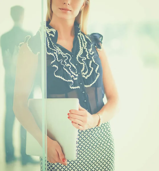 Young businesswoman holding a laptop, standing on office — Stock Photo, Image