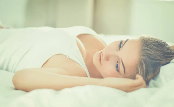 편안하고 행복하게 침대에 누워 있는 아름다운 젊은 여성 — 스톡 사진