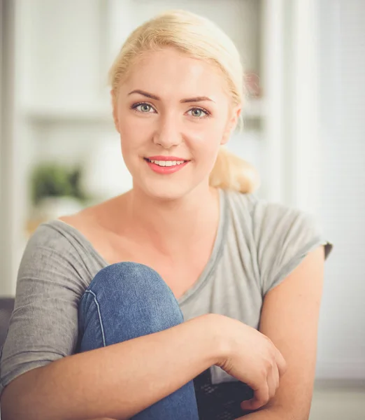 Ung vacker kvinna sitter på soffan på sitt rum — Stockfoto