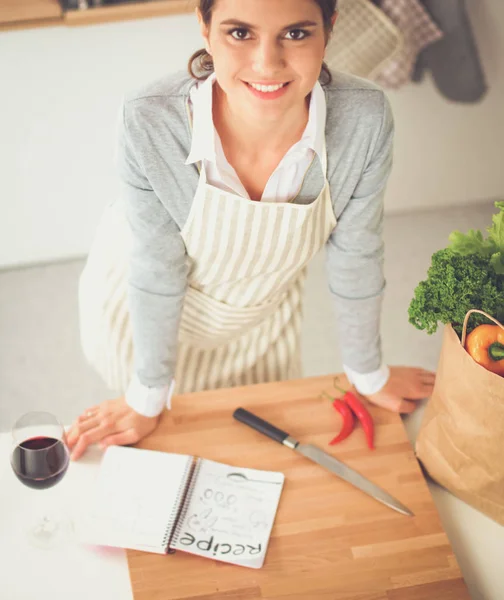 Vrouw met boodschappentassen in de keuken thuis, bij het bureau — Stockfoto