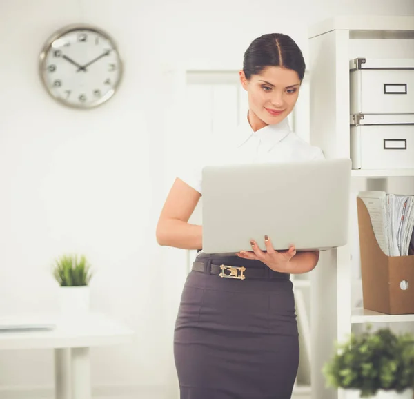 Aantrekkelijke zakenvrouw permanent in kantoor met laptop — Stockfoto