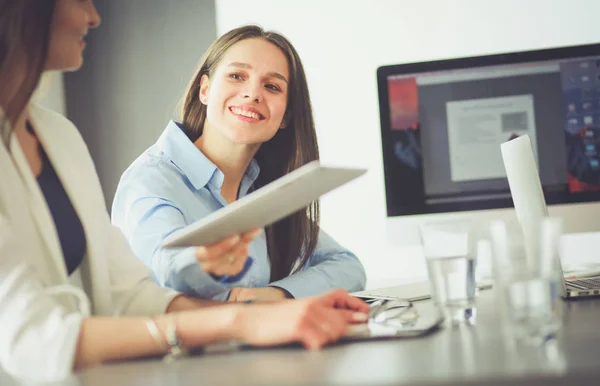 Two female colleagues in office sitting on the desk — Stock Photo, Image