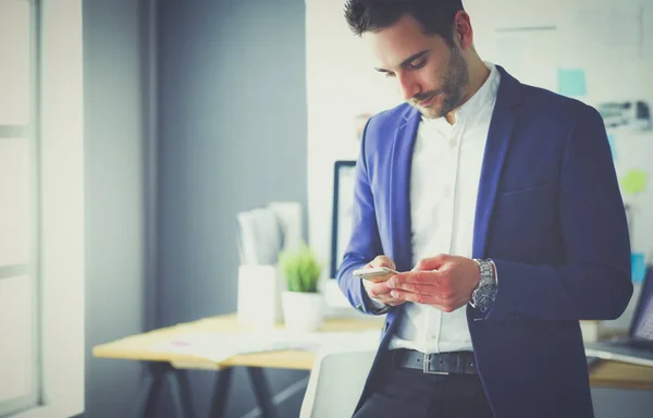 Junger Designer schreibt SMS in seinem Büro — Stockfoto