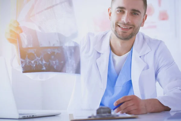 Handsome doctor is talking with young female patient and making notes while sitting in his office. — Stock Photo, Image
