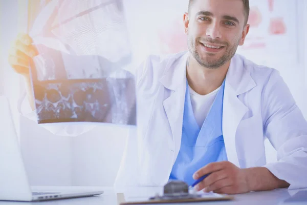 Schöner Arzt spricht mit junger Patientin und macht sich Notizen, während er in seinem Büro sitzt. — Stockfoto