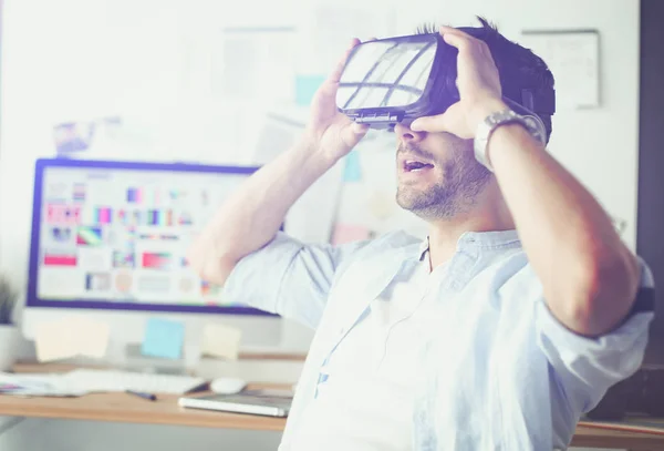 Young male software programmer testing a new app with 3d virtual reality glasses in office.