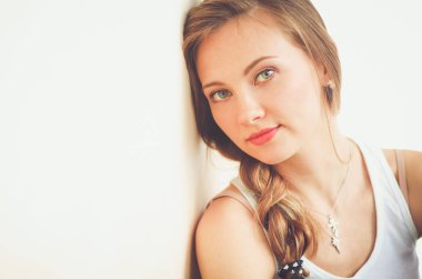 Duvarının yakınında katta oturan bir genç bayan. Genç kadın