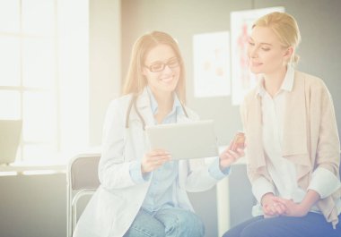 Doktor ve hasta masada otururken bir şey tartışıyorlar. İlaç ve sağlık hizmetleri kavramı