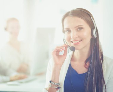 Ofisinde kulaklık ve bilgisayarla gülümseyen iş kadını ya da yardım hattı operatörü