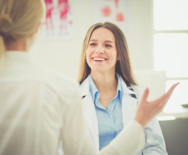 Doktor ve hasta masada otururken bir şey tartışıyorlar. İlaç ve sağlık hizmetleri kavramı