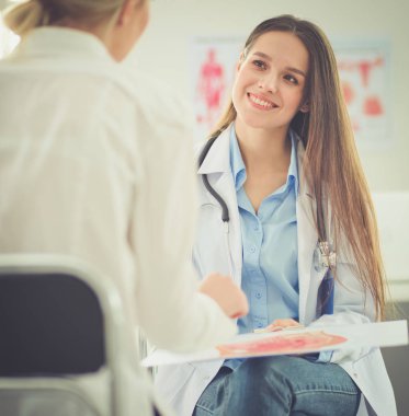 Doktor ve hasta masada otururken bir şey tartışıyorlar. İlaç ve sağlık hizmetleri kavramı