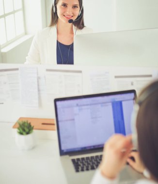 Ofisinde kulaklık ve bilgisayarla gülümseyen iş kadını ya da yardım hattı operatörü