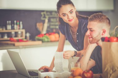 Çift evde mutfak içinde laptop ile onların fatura ödeme
