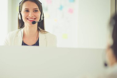 Ofisinde kulaklık ve bilgisayarla gülümseyen iş kadını ya da yardım hattı operatörü