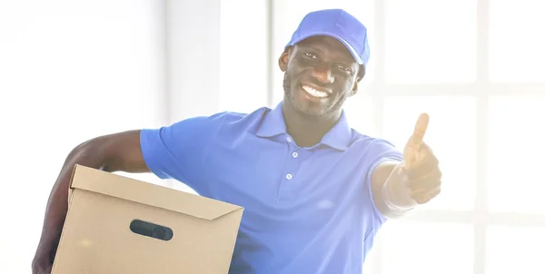 Retrato de un guapo entregador feliz con caja — Foto de Stock