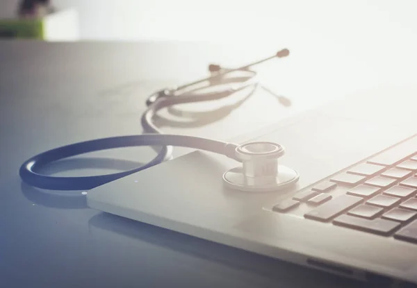 Lugar de trabajo del médico con portátil y estetoscopio y portátil — Foto de Stock