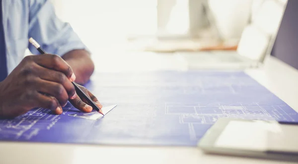 Architecte afro-américain travaillant avec l'ordinateur et les plans dans le bureau — Photo