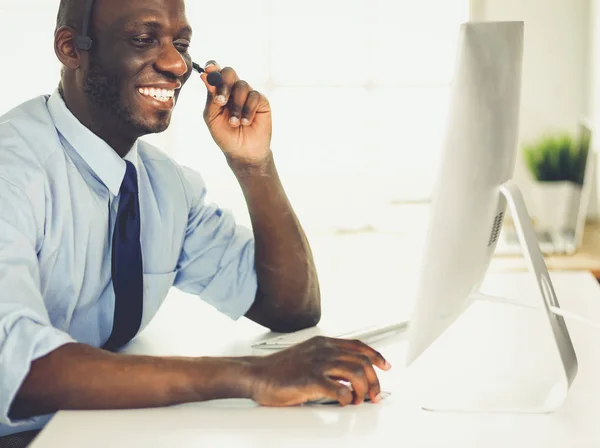 African american businessman on headset working on his laptop — Stock Photo, Image