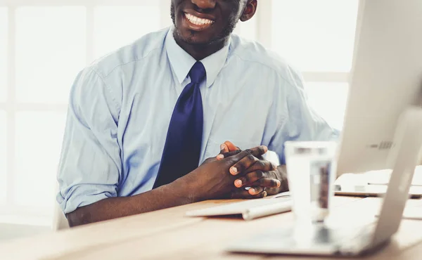 Stilig Afro amerikansk affärsman i klassisk kostym är att använda en laptop och leende medan arbetande i kontor — Stockfoto
