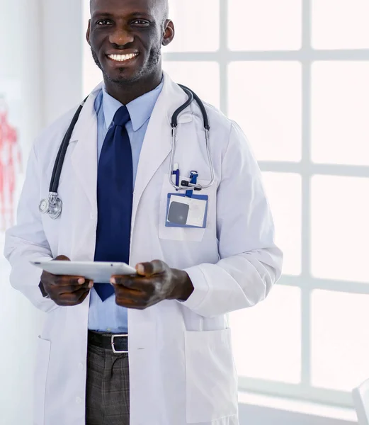 Чоловік чорний лікар з планшетним комп'ютером, що стоїть в лікарні — стокове фото