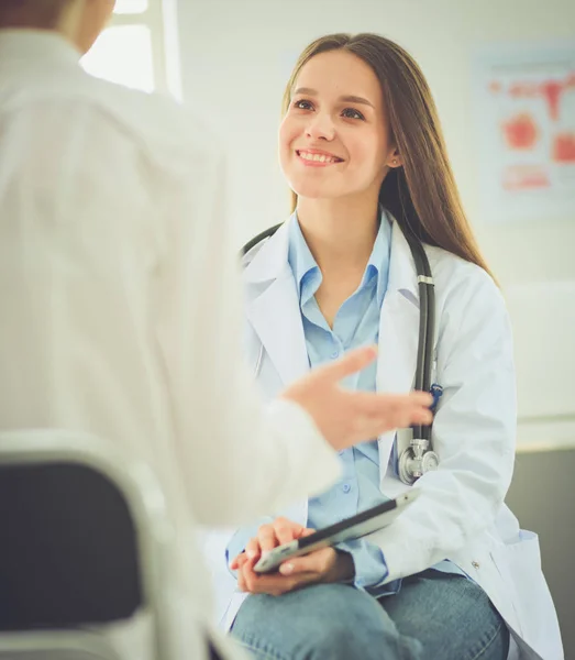 Docteur et patient discutant de quelque chose assis à la table. Médecine et soins de santé concept — Photo