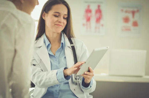 Doktorn och patienten diskuterar något när de sitter vid bordet. Medicin och hälsovård — Stockfoto