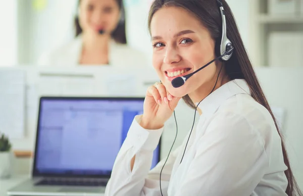 Empresária sorridente ou operador de linha de ajuda com fone de ouvido e computador no escritório — Fotografia de Stock
