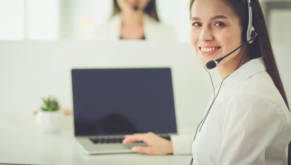 Empresária sorridente ou operador de linha de ajuda com fone de ouvido e computador no escritório — Fotografia de Stock