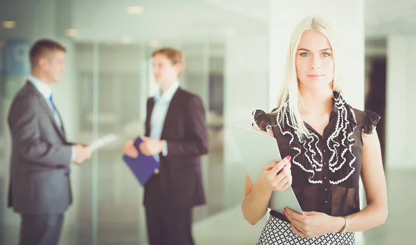 Portret van jonge zakenvrouw in functie met collega 's op de achtergrond . — Stockfoto