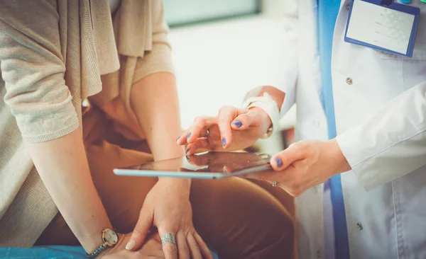 Dokter en patiënt bespreken iets terwijl ze aan tafel zitten. Geneeskunde en gezondheidszorg. Dokter en patiënt — Stockfoto