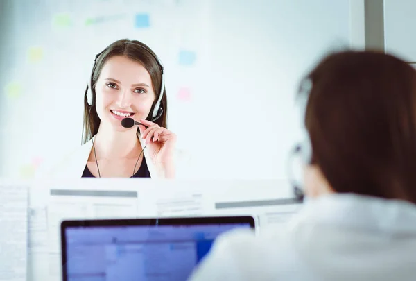 Mujer de negocios sonriente u operador de línea de ayuda con auriculares y computadora en la oficina —  Fotos de Stock