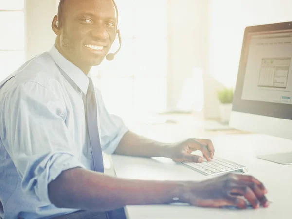 African american businessman on headset working on his laptop — Stock Photo, Image