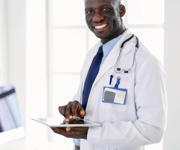 Άνδρας μαύρος γιατρός εργαζόμενος με tablet υπολογιστή στέκεται στο νοσοκομείο — Φωτογραφία Αρχείου