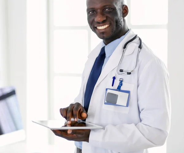 Male black doctor worker with tablet computer standing in hospital — Stock Photo, Image