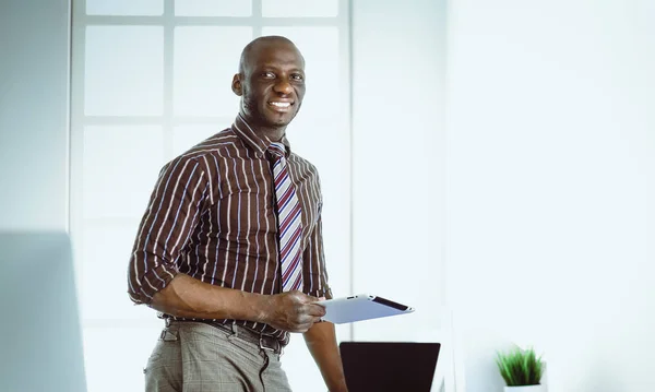 Afrikanischer Architekt arbeitet mit Computer und Bauplänen im Büro — Stockfoto