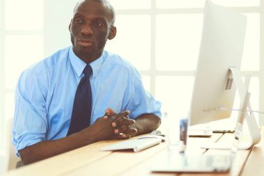 Kulaklıklı Afro-Amerikan işadamı laptopuyla çalışıyor.
