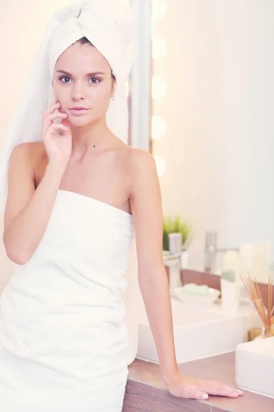 Mladá atraktivní žena stojící před zrcadlo do koupelny — Stock fotografie