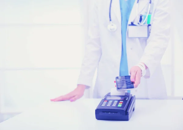 Doktor ödeme terminalini elinde tutuyor. Sağlık hizmetlerinin parasını ödüyorum. Doktor. — Stok fotoğraf