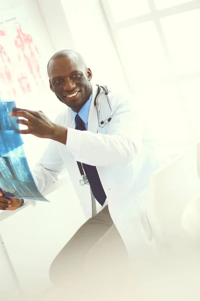 Genç Afrikalı doktor portresi hastaların röntgenlerini tutuyor. — Stok fotoğraf
