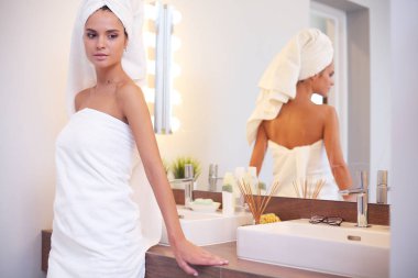 Banyo aynası önünde duran genç çekici kadın