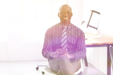 Yakışıklı Afro Amerikalı işadamı Klasik takım elbiseli bir dizüstü bilgisayar kullanarak ve ofiste çalışırken gülümseyen