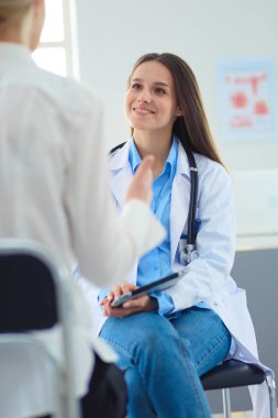 Doktor ve hasta masada otururken bir şey tartışıyorlar. İlaç ve sağlık hizmetleri kavramı