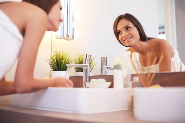 Attraente giovane donna che applica la crema sul suo viso — Foto Stock