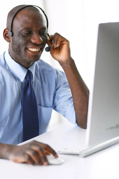 Uomo d'affari afroamericano in cuffia che lavora sul suo portatile — Foto Stock